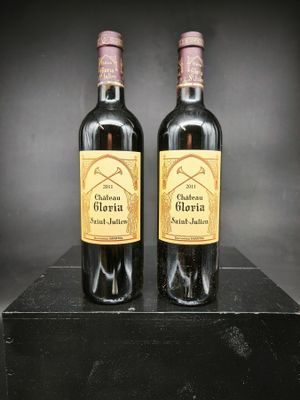 deux bouteilles de vin posées sur une boîte noire