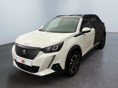 Un SUV blanc est garé dans une pièce au sol noir.