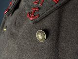a close up of a coat with a red ribbon on it