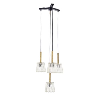 un lustre noir et doré avec trois ampoules en verre transparent suspendues au plafond