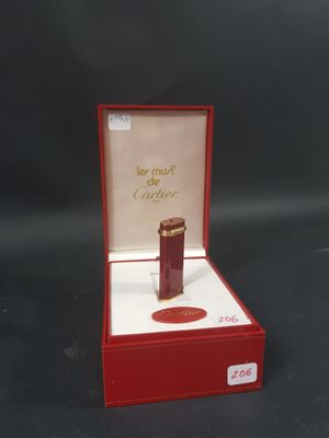 une petite boîte rouge contenant un flacon de parfum