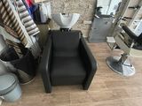 une chaise noire dans une pièce où il y a un miroir accroché au mur
