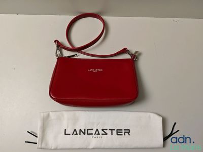 a close up of a red purse and a white bag on a table