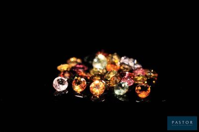 several different colored gems are arranged on a black surface