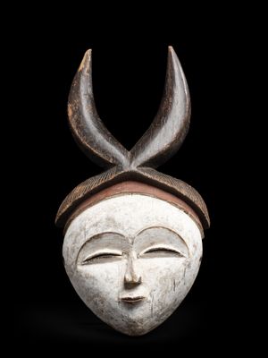 un gros plan d'un masque en bois orné de cornes