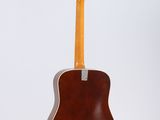 an acoustic guitar hanging from a wall with a white background