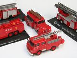 quatre camions de pompiers rouges exposés sur un fond blanc