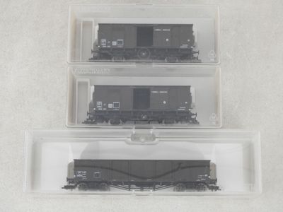 trois récipients en plastique sur lesquels est posé un train, posés sur une surface blanche