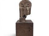a statue of a woman sitting on top of a wooden block
