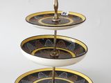 a three tiered cake stand with a gold and black design