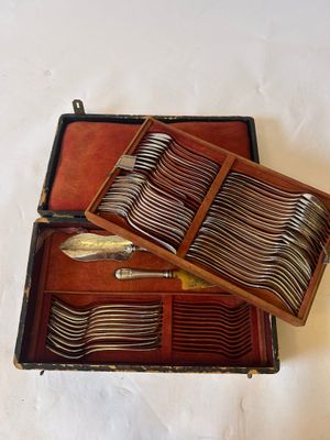 a wooden case with silverware in it on a white surface