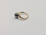 a close up of a gold ring with a black pearl on it