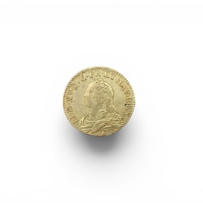 gros plan d'une pièce d'or sur une surface blanche