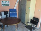 une pièce équipée d'une table, de chaises et d'un réfrigérateur