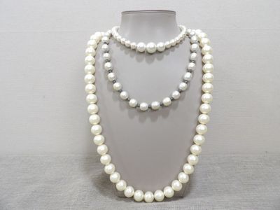 un gros plan d'un collier blanc orné de perles sur un mannequin