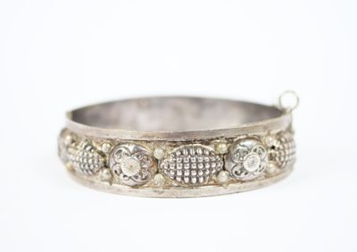 un gros plan d'un bracelet en argent serti de diamants sur fond blanc