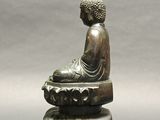 bronze statue of a seated person on a lotus flower