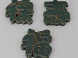 three pieces of green ceramic with chinese characters on them