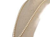 pearl necklace on a mannequin neck with a white background
