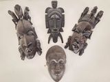 Plusieurs masques africains sont exposés sur un fond blanc
