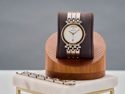 une montre posée sur un socle en bois, sur une table