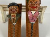 pair of wooden wine openers with faces on them on a table