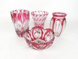 three red glass vases sitting next to each other on a white surface