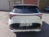 the rear end of a white car parked in a parking lot