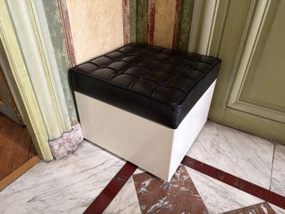 un pouf noir et blanc posé sur un sol en marbre