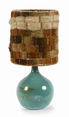 a blue vase with a woven shade on top of it