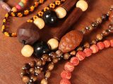 a wooden bead necklace on a table with other beads