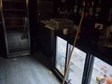 une serpillière et un balai devant un réfrigérateur