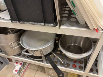 de nombreuses casseroles et poêles sur l'étagère de la cuisine