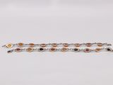 a silver bracelet with orange and black stones