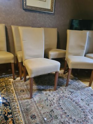 plusieurs chaises blanches dans une pièce où il y a un tapis au sol