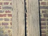 deux grands piliers en pierre devant un mur de briques