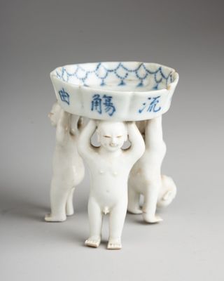 two cats holding a bowl on top of each other