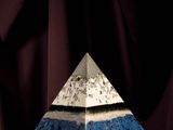 a close up of a pyramid shaped object on a purple surface