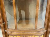 a wooden display case with a glass door on top of it
