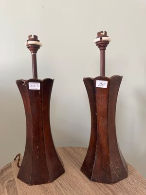 une paire de lampes en bois posées sur une table, avec un mur blanc en arrière-plan