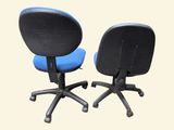 pair of blue office chairs on castors against a white background