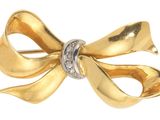 une image représentant une broche en forme de nœud en or sertie de diamants