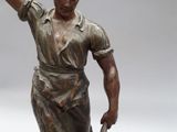 a statue of a man holding a hammer and a bucket