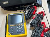 un équipement électrique jaune et noir posé sur une table à côté d'un sac noir