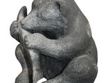 a statue of a bear that is sitting on a branch