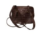 the small brown purse is sitting on a white surface
