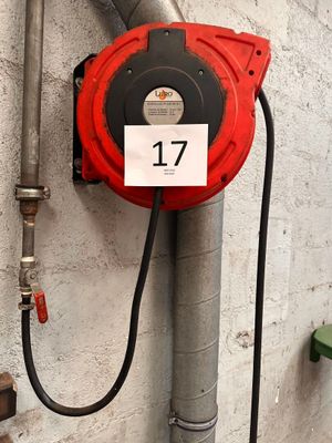 une borne d'incendie rouge fixée à un mur et portant le numéro 17