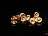 two pieces of gold colored crystal sitting on top of a black surface