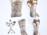 a lot of silver spoons and forks on the table