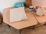 a small table with two pillows and a bag on it